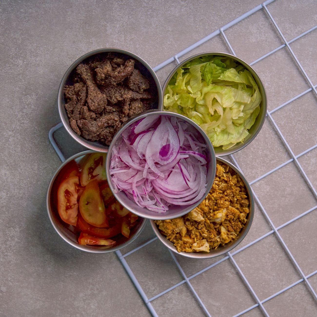 Overhead view of fresh salad ingredients in bowls — colorful produce for healthy family meals.